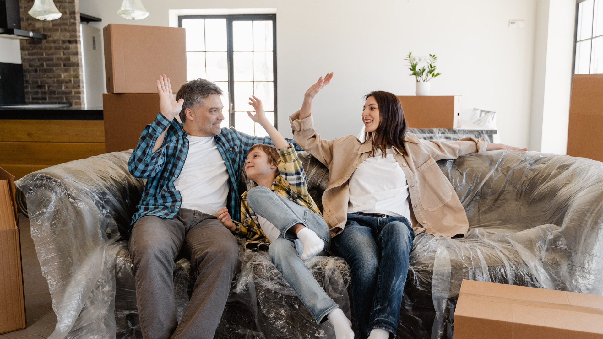 Family relaxes on a plastic covered sofa after moving into their new home