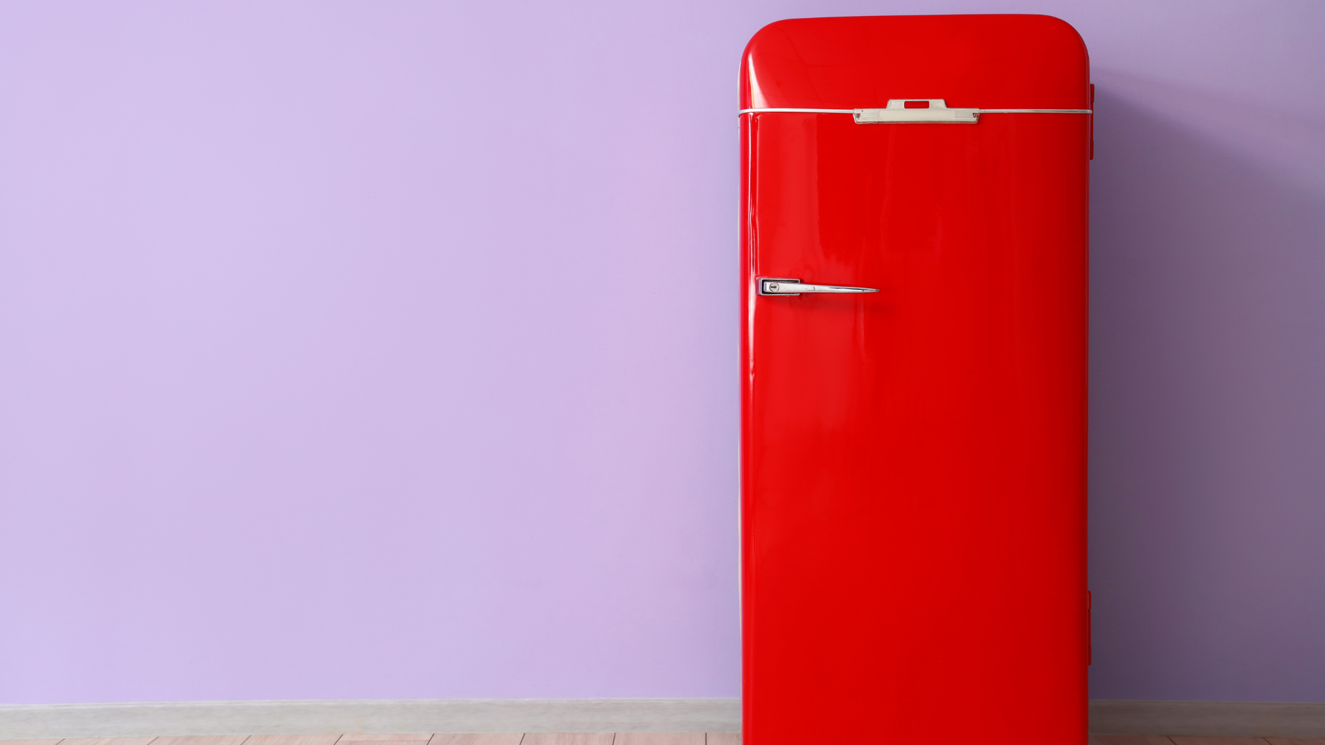 Red fridge against a light purple accent wall
