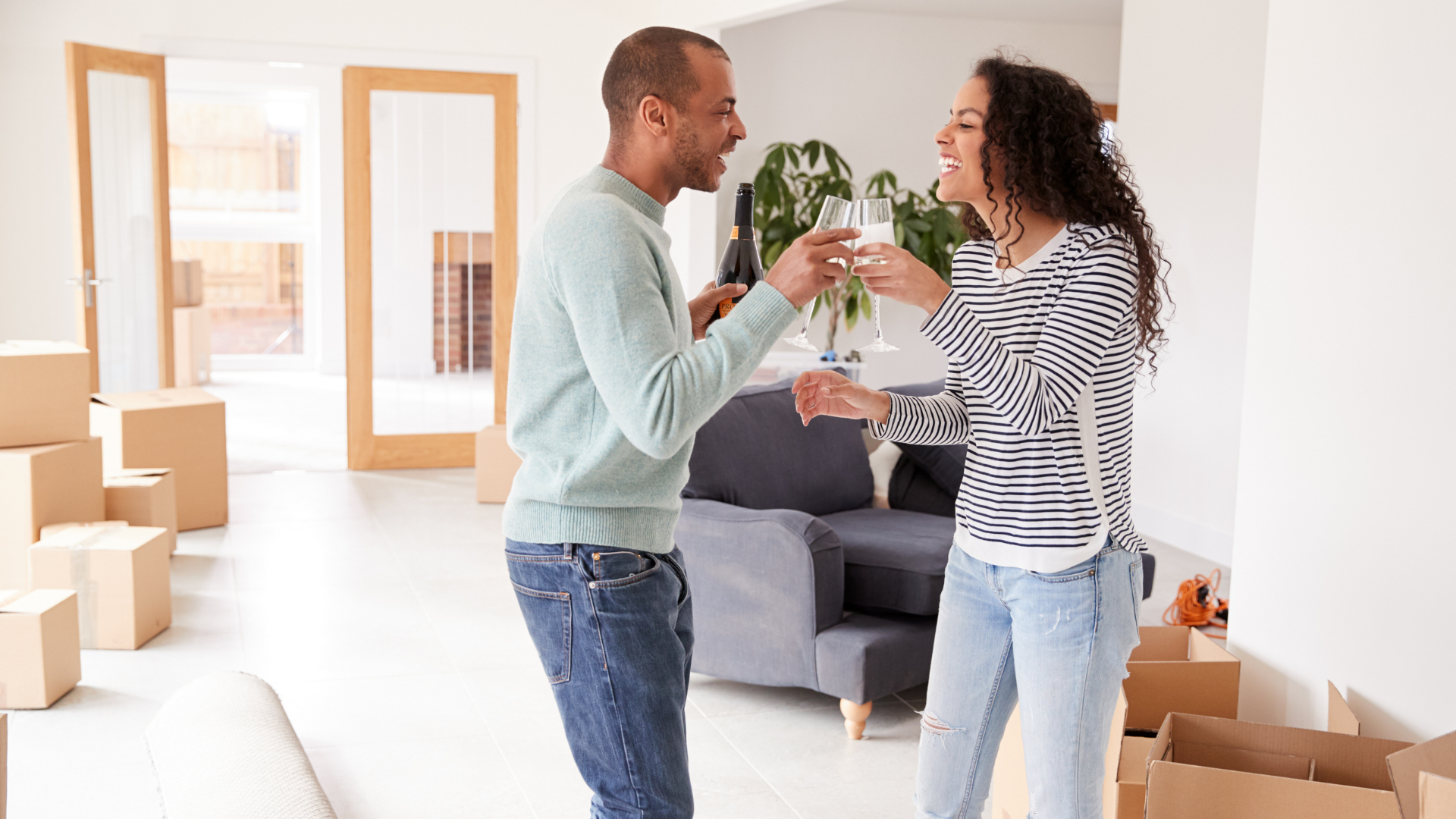Couple Celebrates Buying A Home By Toasting Champagne In Their New Living Room