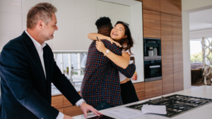 Home Buyers Hugging After Signing A Real Estate Contract