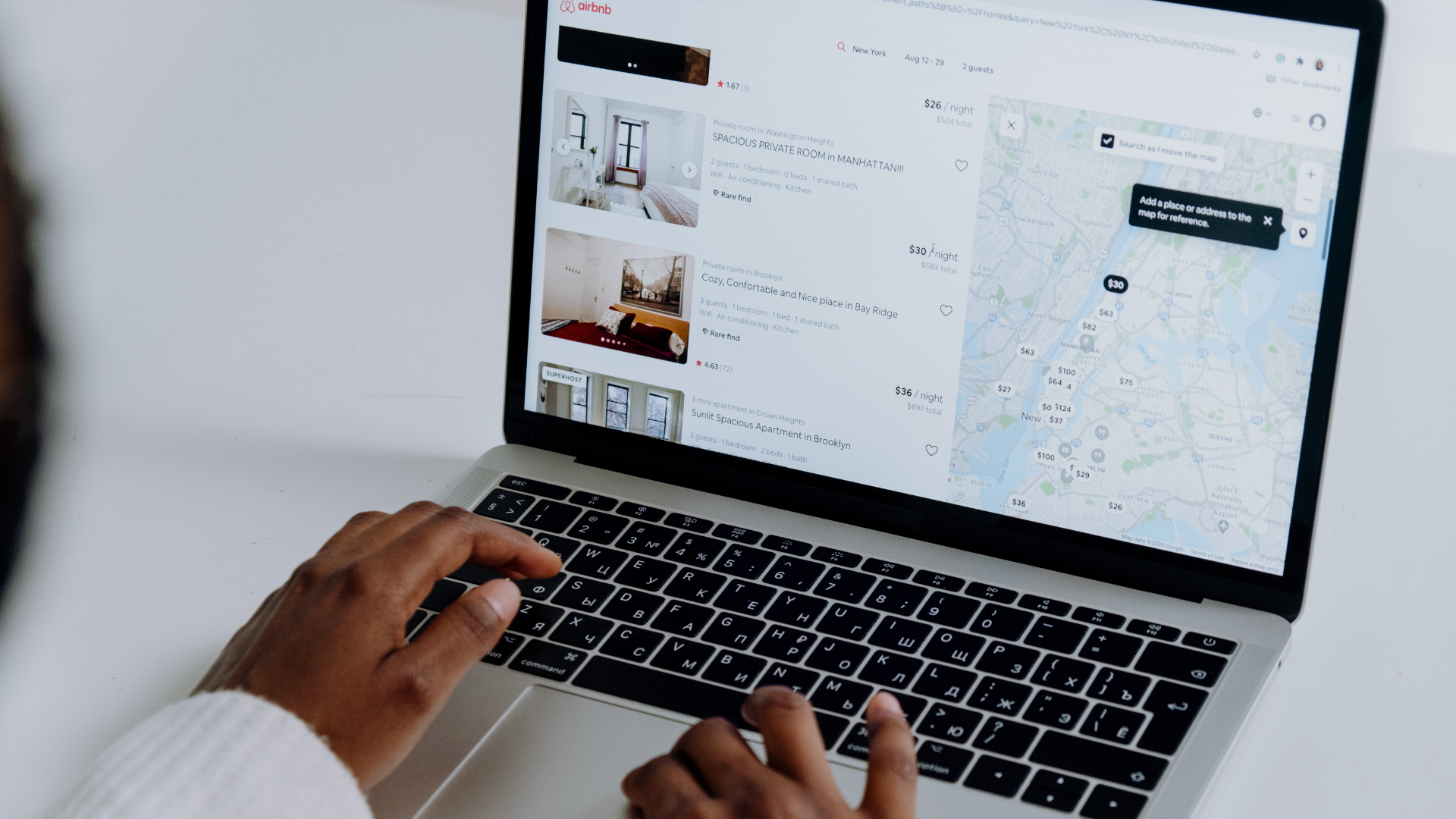 Person on laptop searches hosting Airbnb rentals