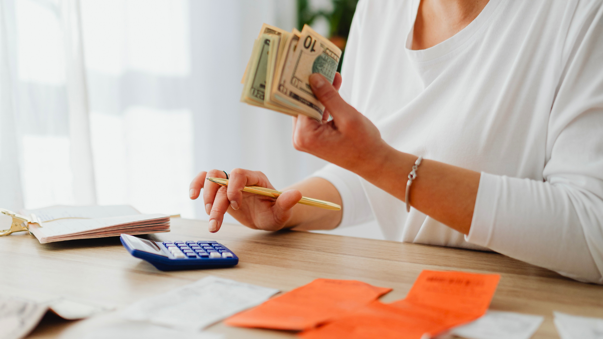 Woman holding money while creating a budget