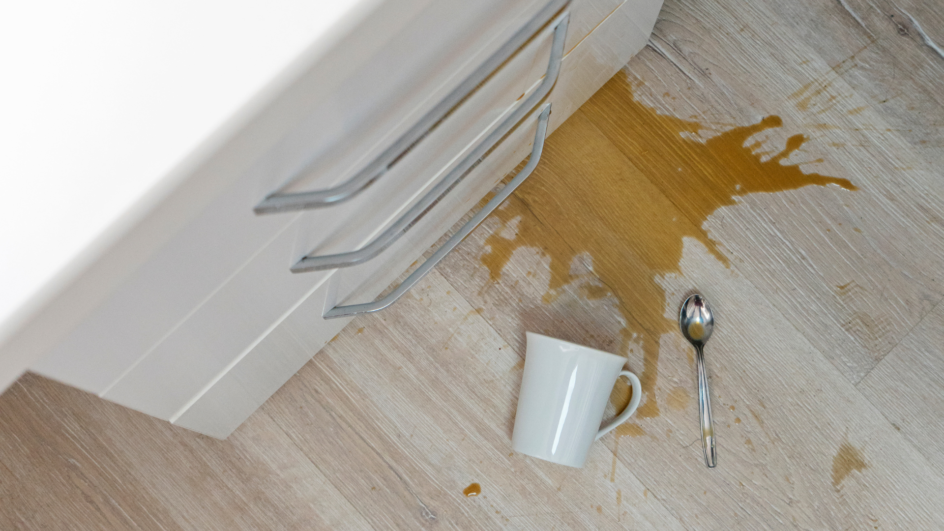 Cup of coffee spilled on waterproof luxury vinyl flooring