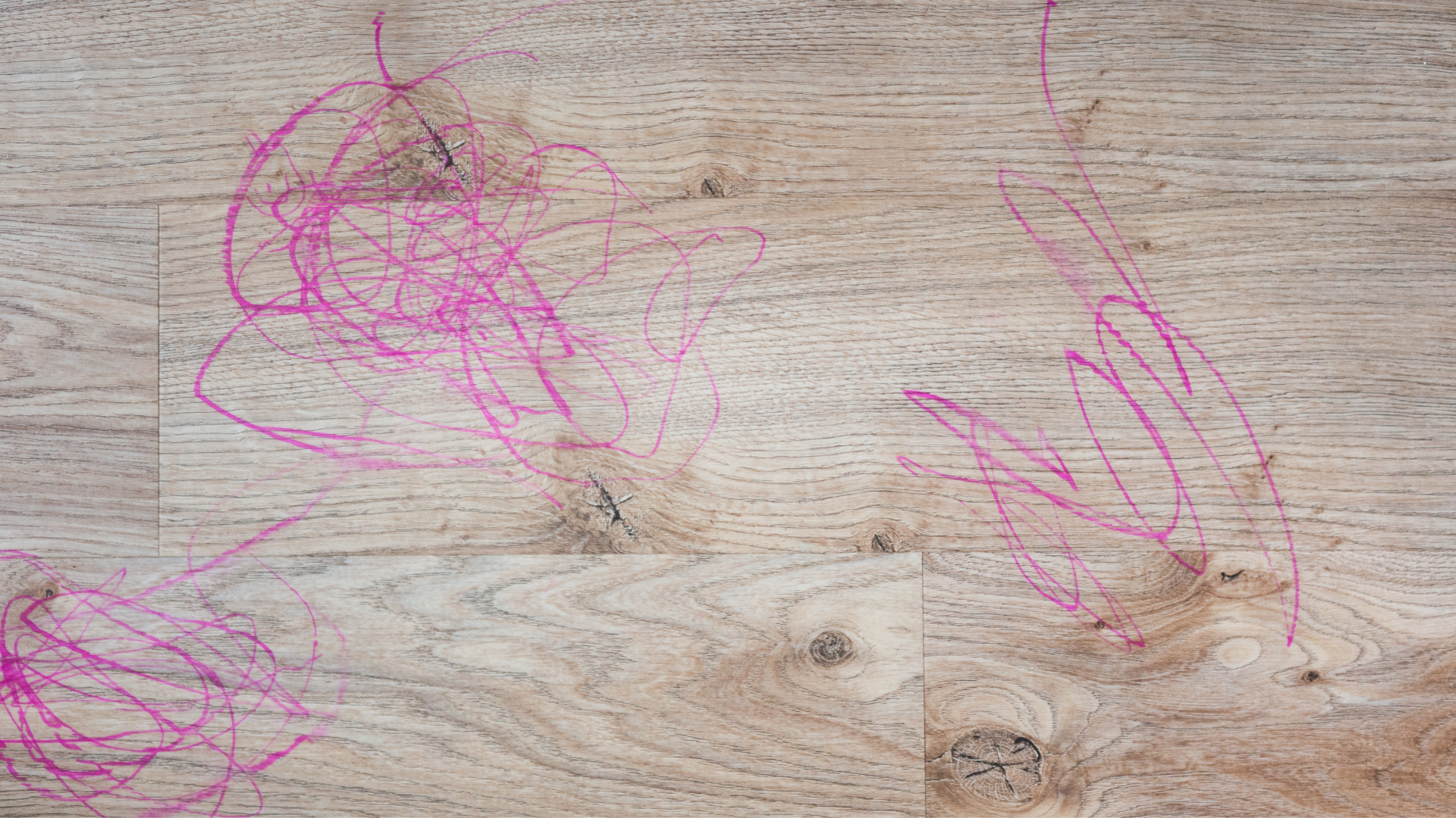 Pink marker colored onto waterproof brown luxury vinyl plank floors