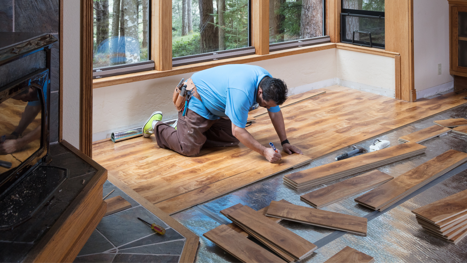 Flooring professional installing wood flooring in a rustic home