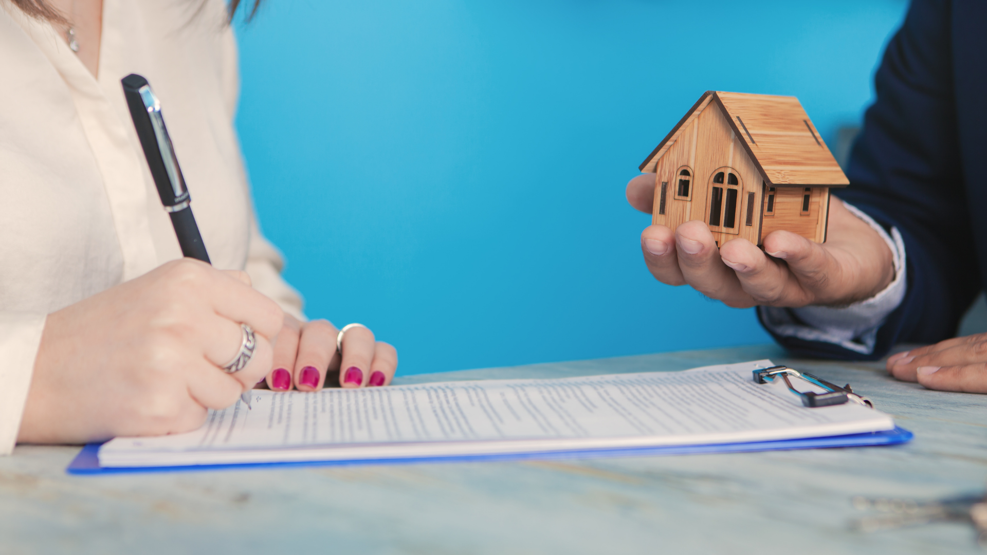 Real estate agent sells to a woman signing a home selling agreement