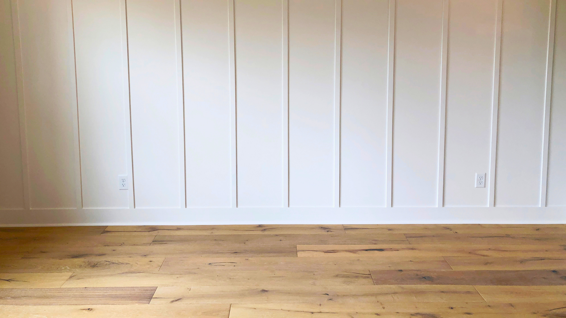 White DIY Board and Batten Accent Wall with Brown Hardwood Flooring